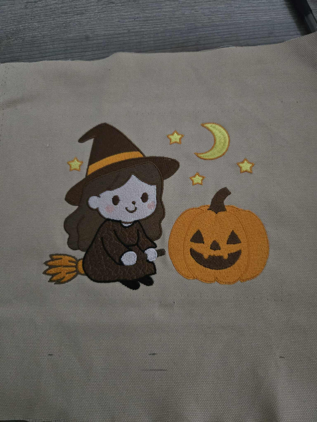 Motif de broderie machine Halloween petite sorcière sur son balai avec citrouille lune et étoiles