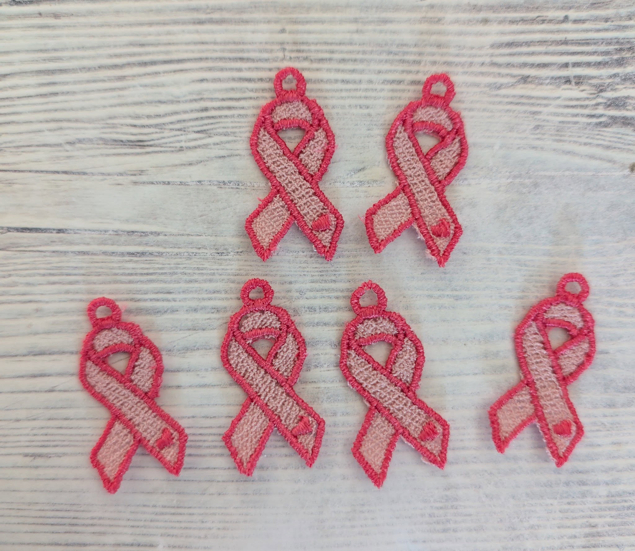 Plaque de broderie FSL Ruban Octobre Rose contenant plusieurs boucles d'oreilles et breloques à broder au format 10x10