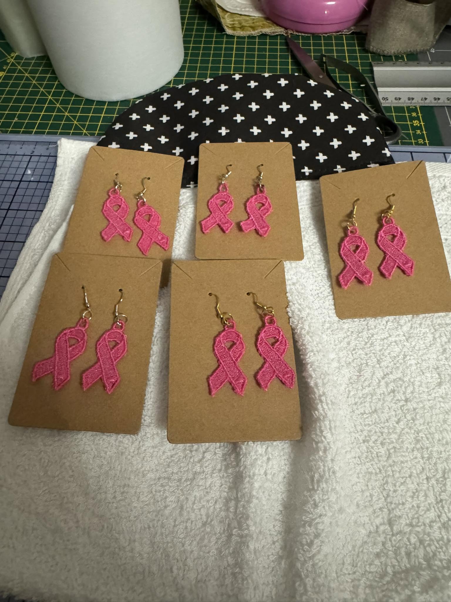 Plaque de broderie FSL Ruban Octobre Rose contenant plusieurs boucles d'oreilles et breloques à broder au format 10x10