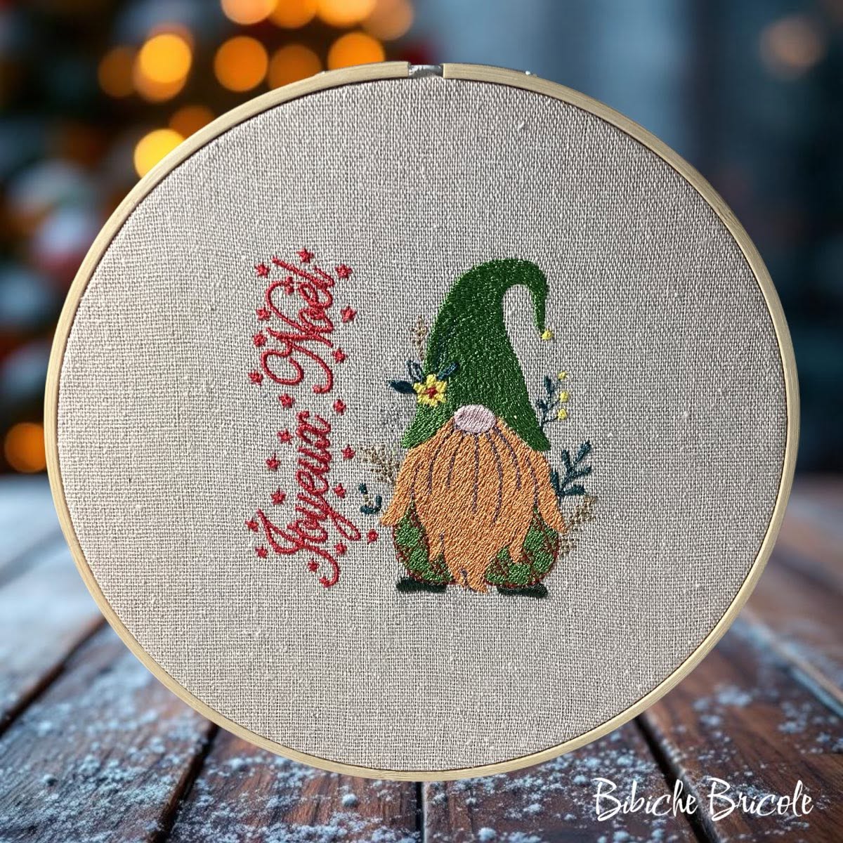 Gnome de Noël avec grand bonnet rouge, barbe blanche, tenue verte, étoiles dorées et inscription Joyeux Noël – motif de broderie machine