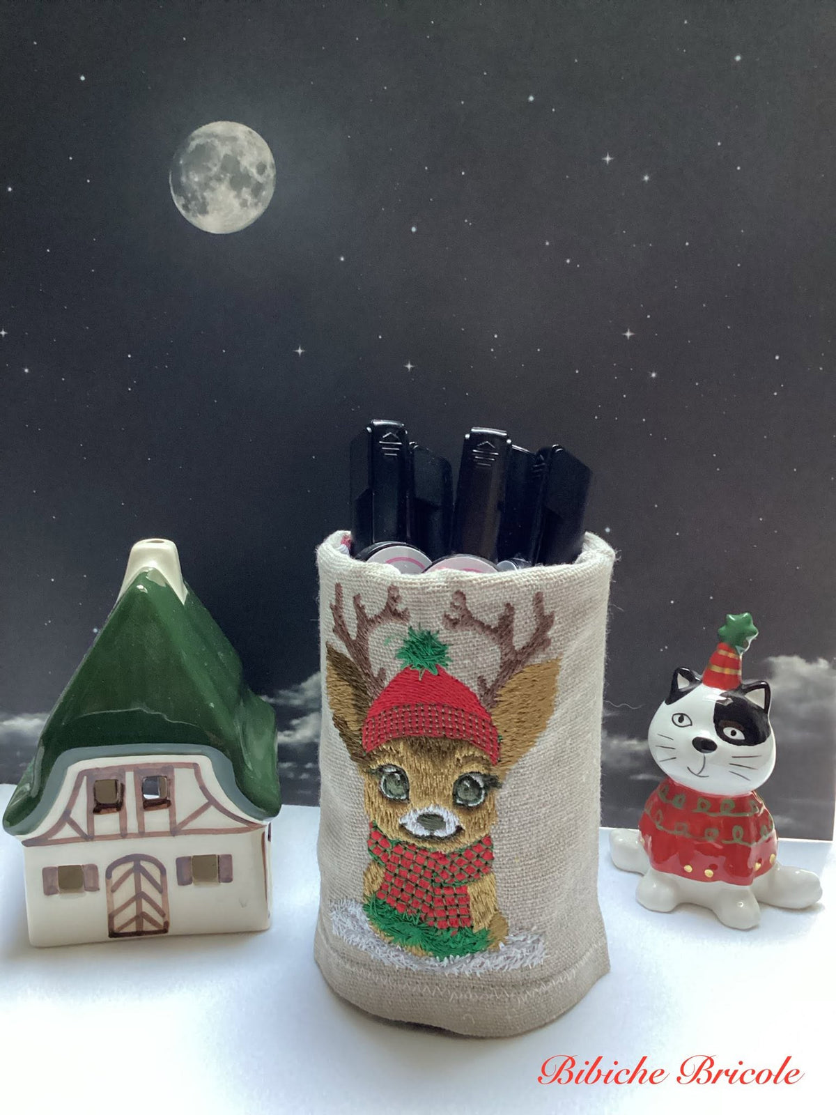 Petit faon de Noël avec grands bois, bonnet rouge, écharpe rouge et noire et neige – motif de broderie machine