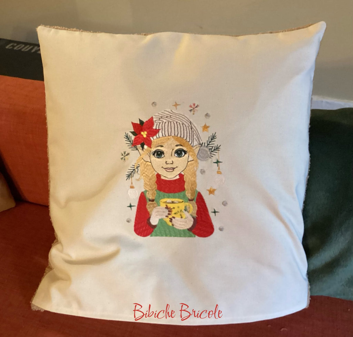 Petite Elfe de Noël avec bonnet rouge, poinsettia, tasse de chocolat chaud, flocons et décor féerique – motif de broderie machine