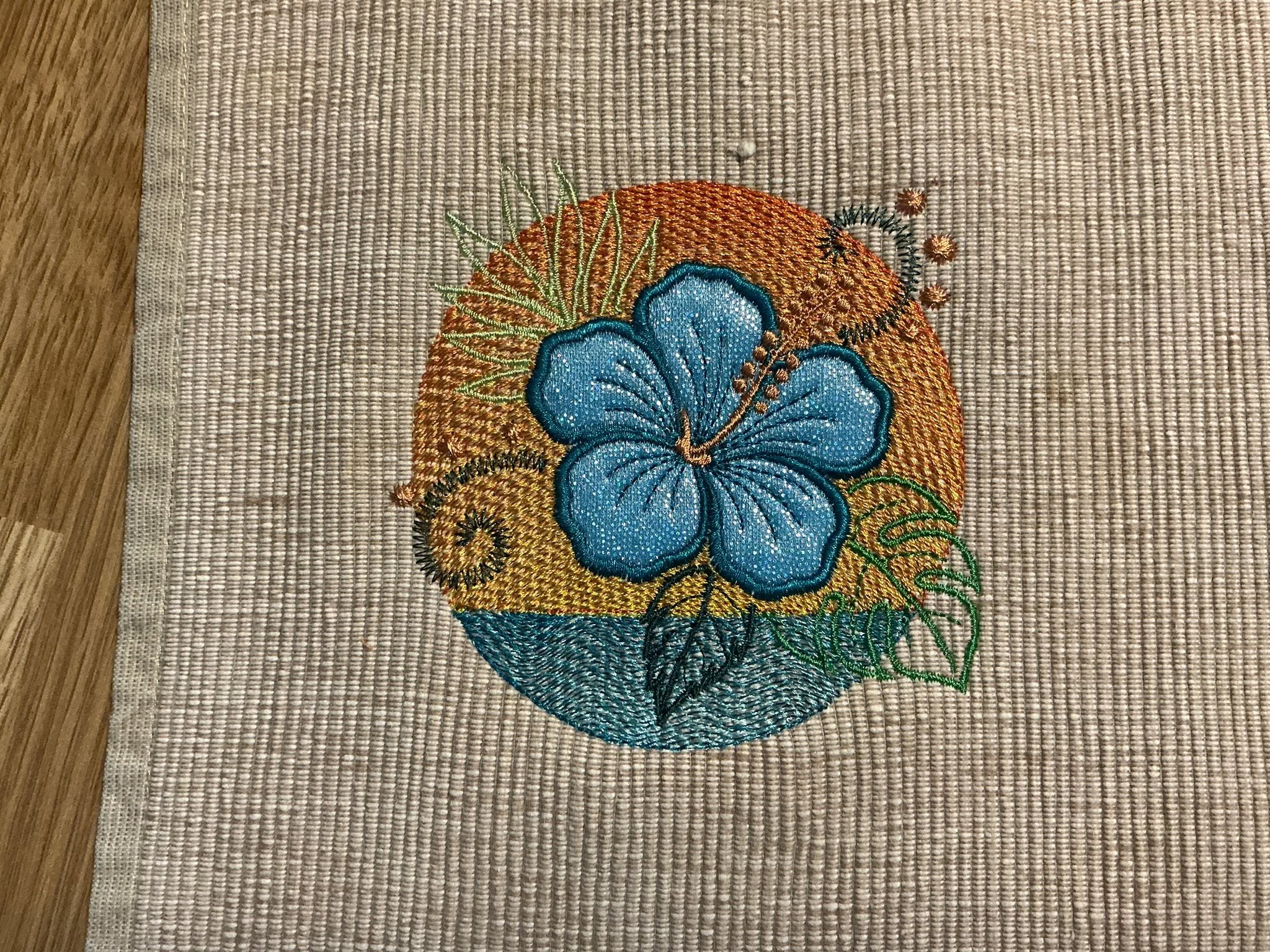 Motif de broderie Hibiscus en appliqué sur coucher de soleil et océan avec effet vagues brodées – Formats 10x10, 15x15 et 18x13 AK Broderie