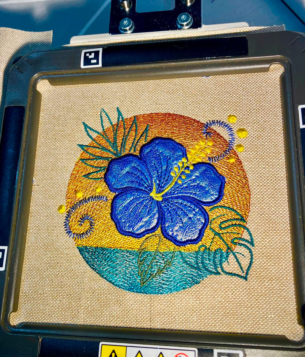 Motif de broderie Hibiscus en appliqué sur coucher de soleil et océan avec effet vagues brodées – Formats 10x10, 15x15 et 18x13 AK Broderie