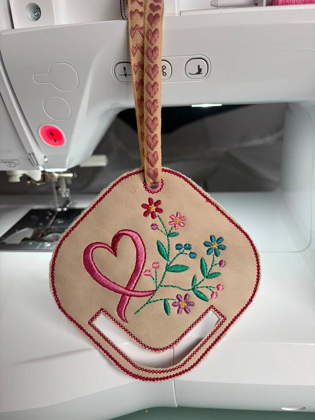 Motif de broderie ITH porte-foulard Ruban & Fleurs Octobre Rose avec ruban rose, fleurs délicates et feuillage, format 10x10