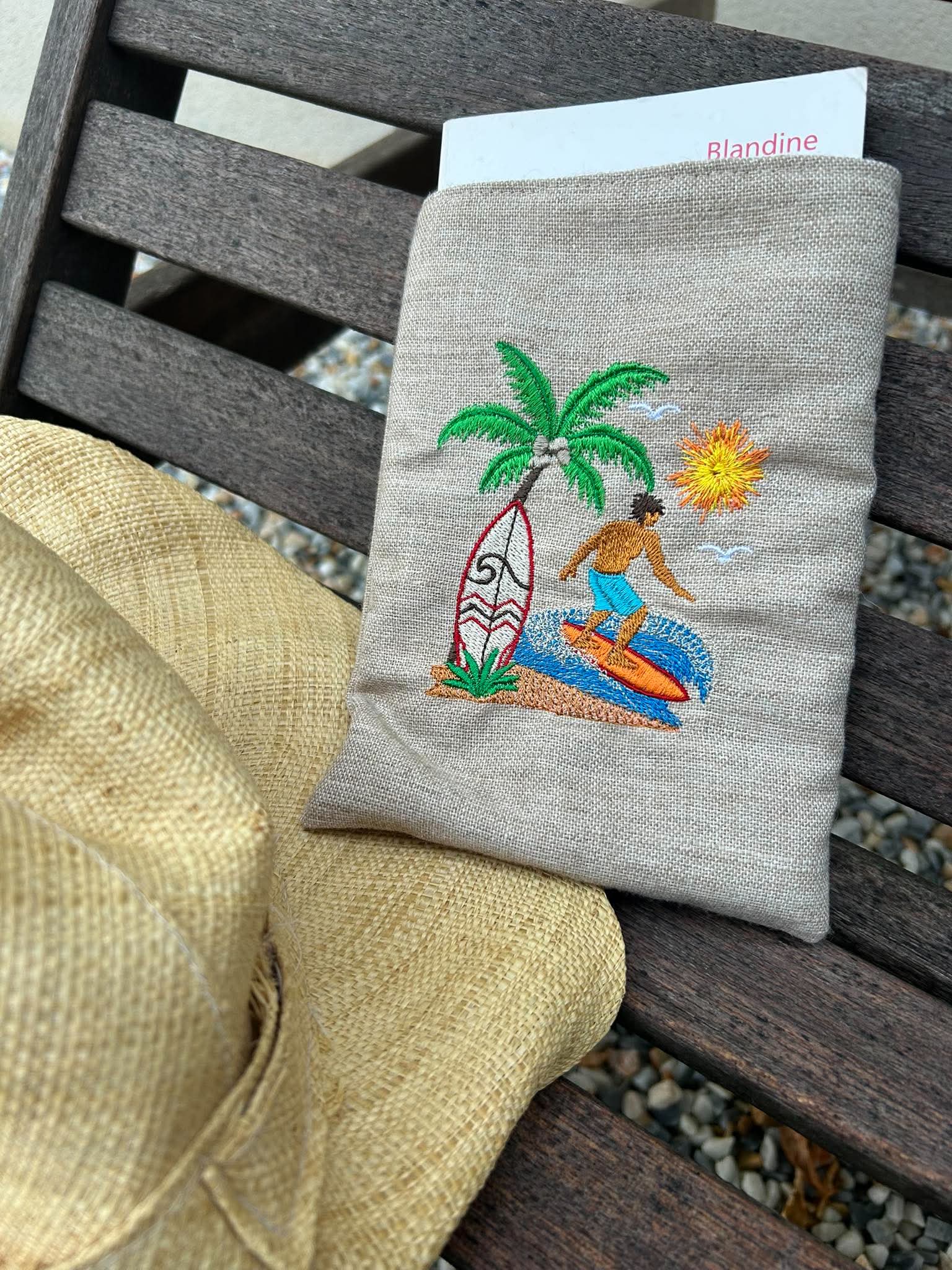 Motif de broderie Surfeur disponible au format 10x10. Décor tropical avec palmier, planche de surf, océan et soleil, idéal pour une ambiance estivale.