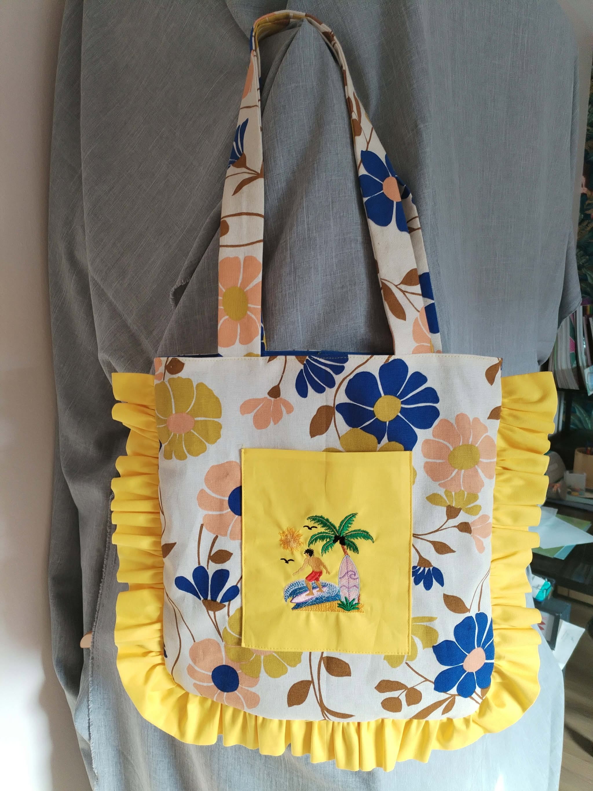 Motif de broderie Surfeur disponible au format 10x10. Décor tropical avec palmier, planche de surf, océan et soleil, idéal pour une ambiance estivale.