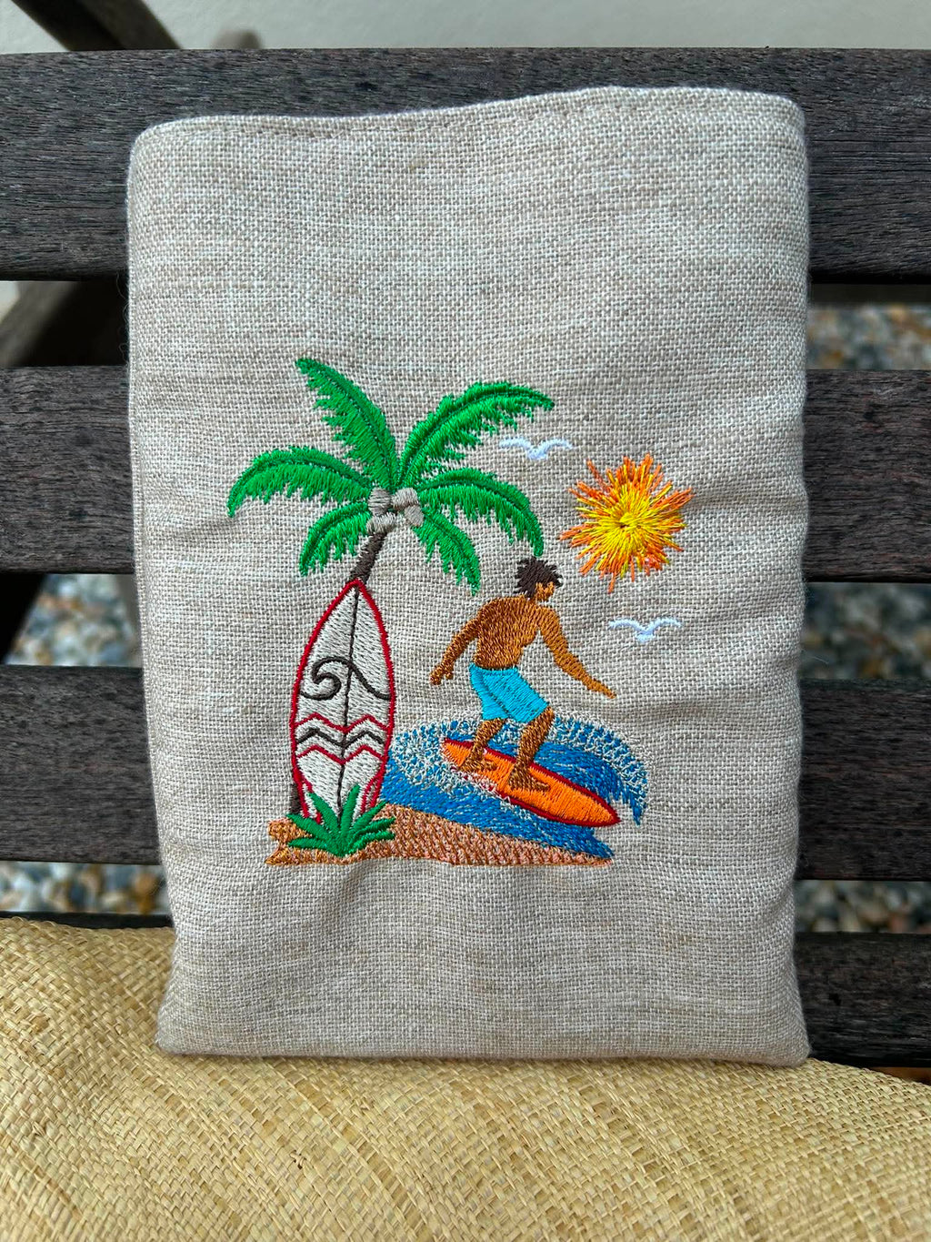Motif de broderie Surfeur disponible au format 10x10. Décor tropical avec palmier, planche de surf, océan et soleil, idéal pour une ambiance estivale.