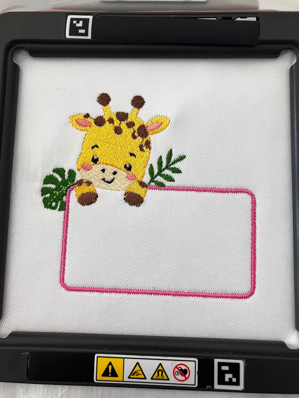 Motif de broderie Étiquette Girafe personnalisable avec feuillages et cadre pour ajouter un prénom ou un texte au format 10x10