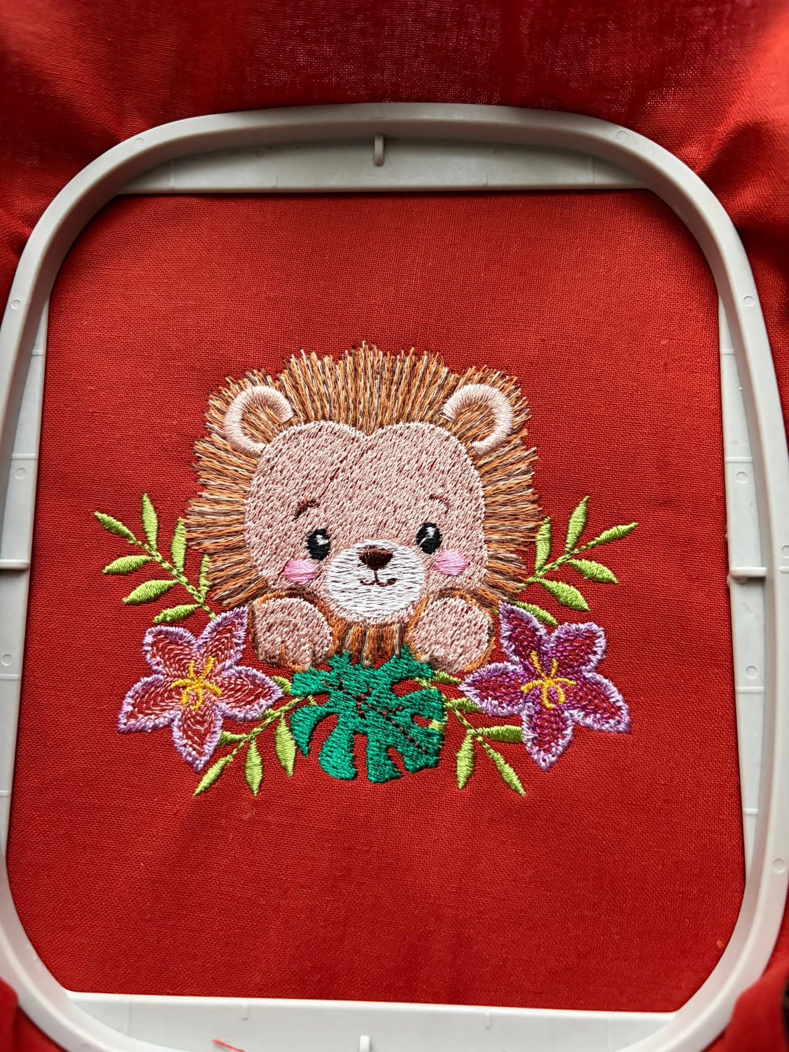 Motif de broderie machine Lionceau Fleuri entouré de fleurs tropicales et feuillages, disponible en 3 tailles
