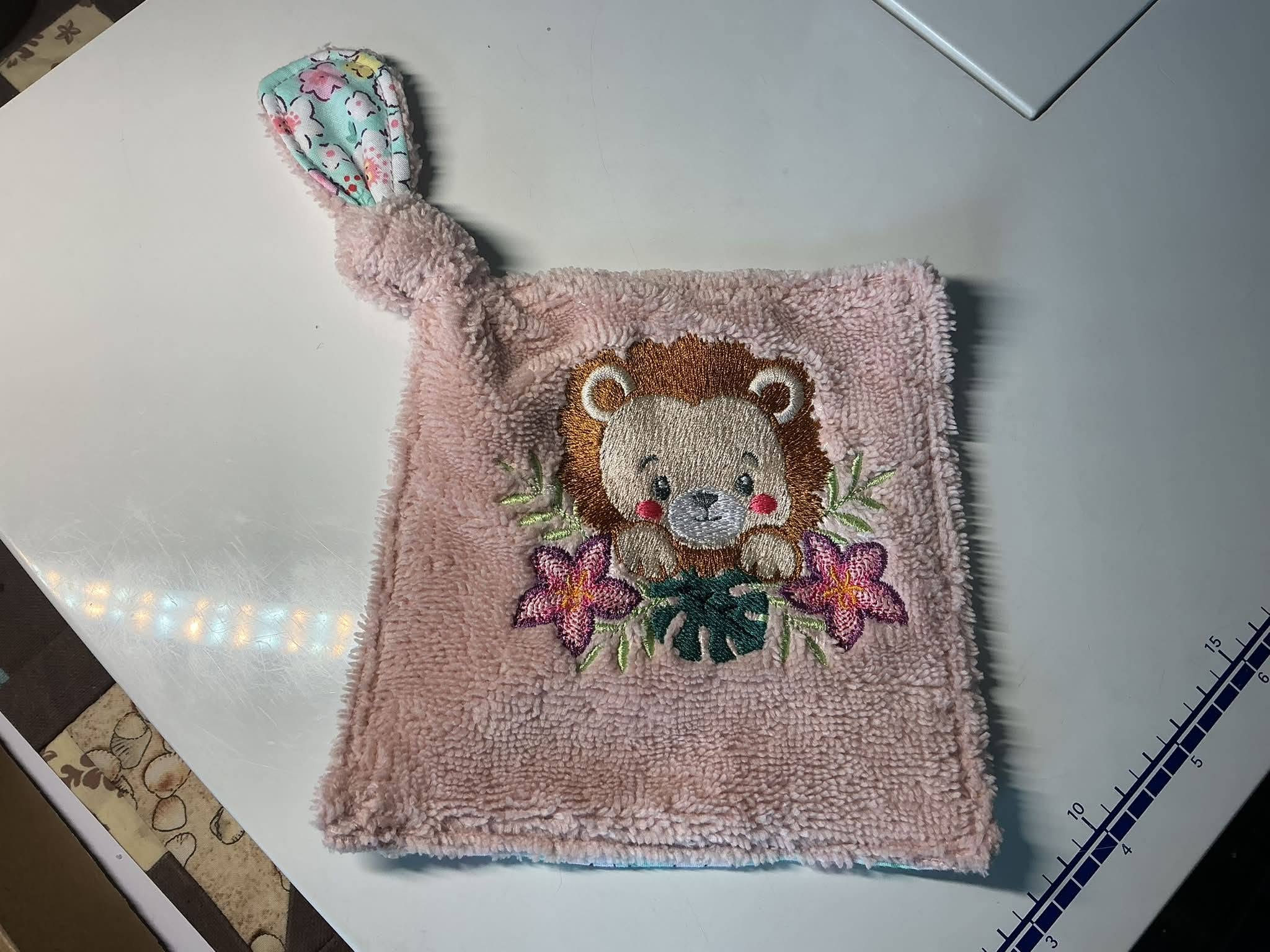 Motif de broderie machine Lionceau Fleuri entouré de fleurs tropicales et feuillages, disponible en 3 tailles