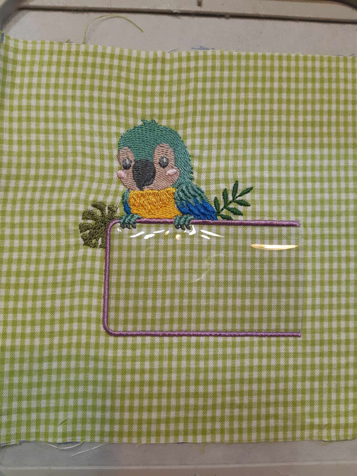 Étiquette Appliqué Cristal Perroquet – motif de broderie machine 10x10 avec perroquet, feuillage et fenêtre transparente en Cristal
