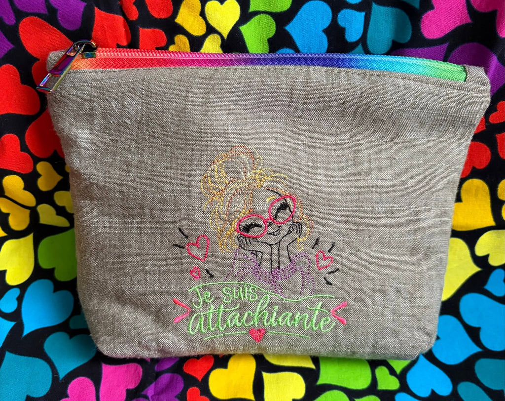 Je suis Attachiante – femme avec chignon, grandes lunettes rouges et petits cœurs – motif de broderie machine humour