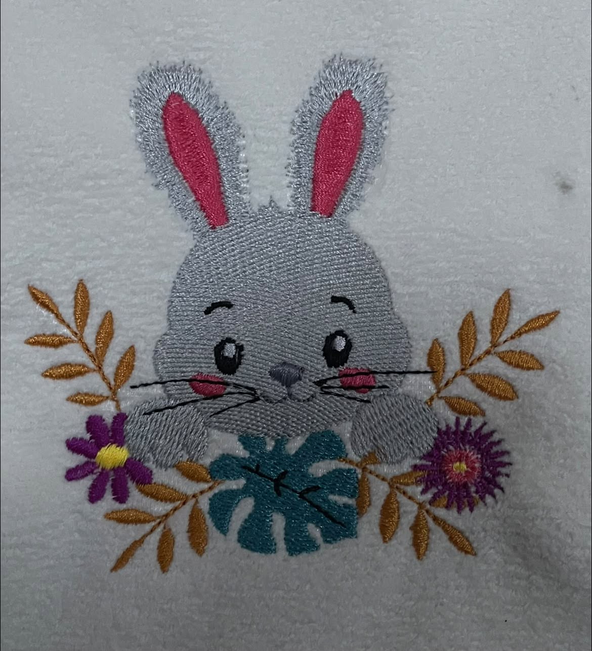 Lapin Fleuri entouré de fleurs et feuillages – motif de broderie machine disponible en 3 tailles