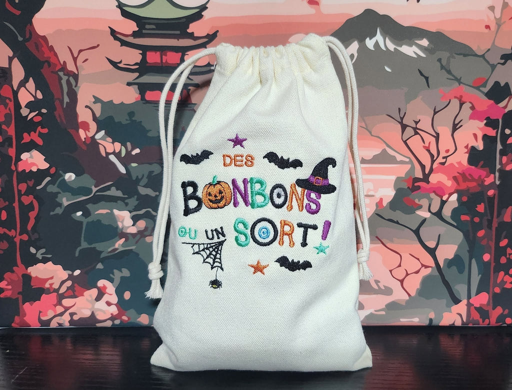Motif broderie Halloween Des Bonbons ou un Sort ! avec citrouille, sorcière, chauves-souris et araignée. Disponible en formats 10x10 et 15x15.