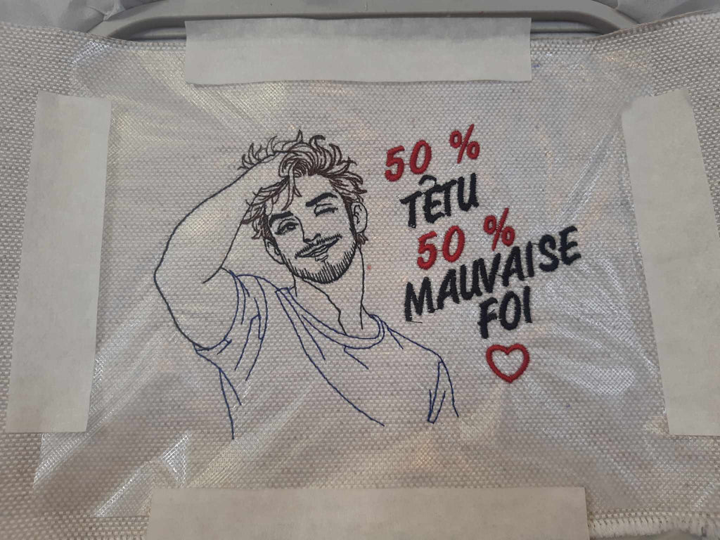 50 % Têtu 50 % Mauvaise Foi – homme souriant et malicieux – motif de broderie machine humour disponible en 10x10 et 15x15