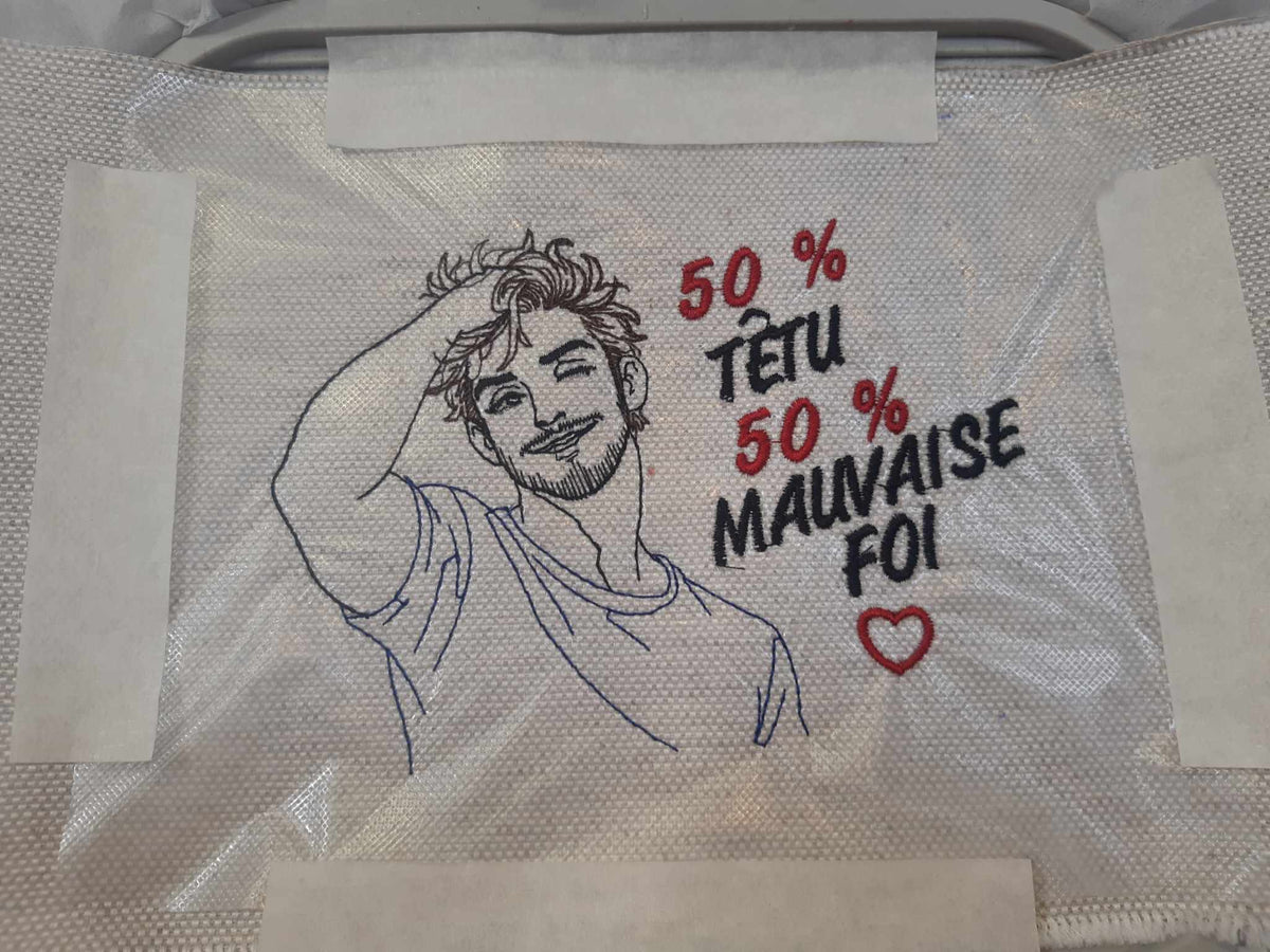 50 % Têtu 50 % Mauvaise Foi – homme souriant et malicieux – motif de broderie machine humour disponible en 10x10 et 15x15