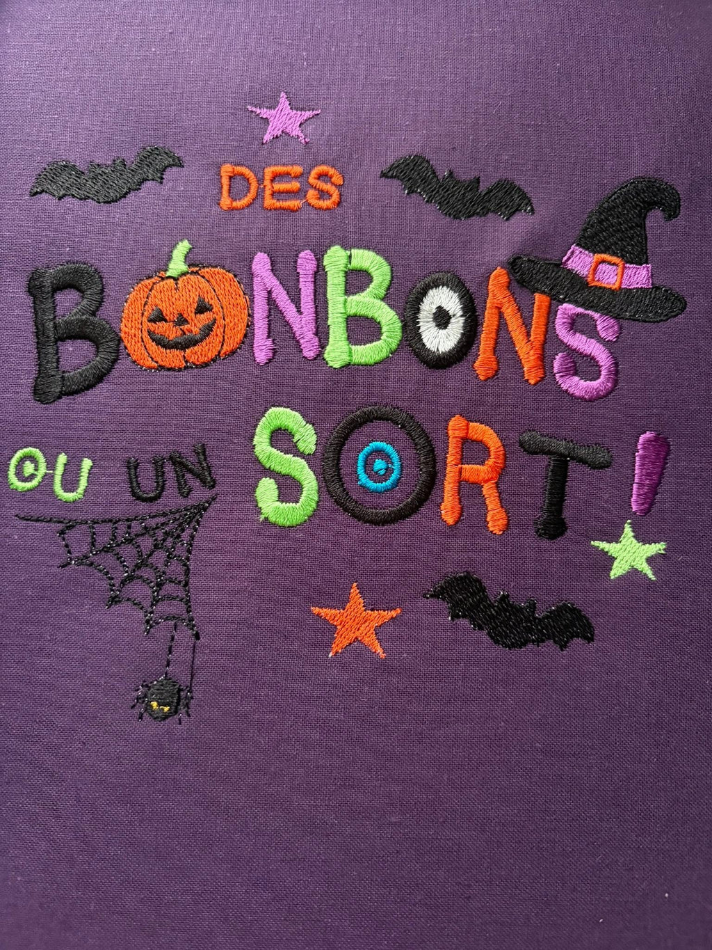 Motif broderie Halloween Des Bonbons ou un Sort ! avec citrouille, sorcière, chauves-souris et araignée. Disponible en formats 10x10 et 15x15.