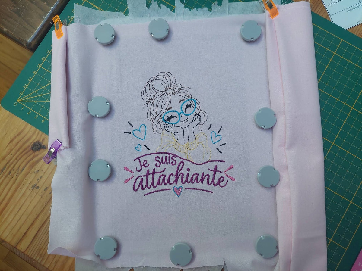Je suis Attachiante – femme avec chignon, grandes lunettes rouges et petits cœurs – motif de broderie machine humour