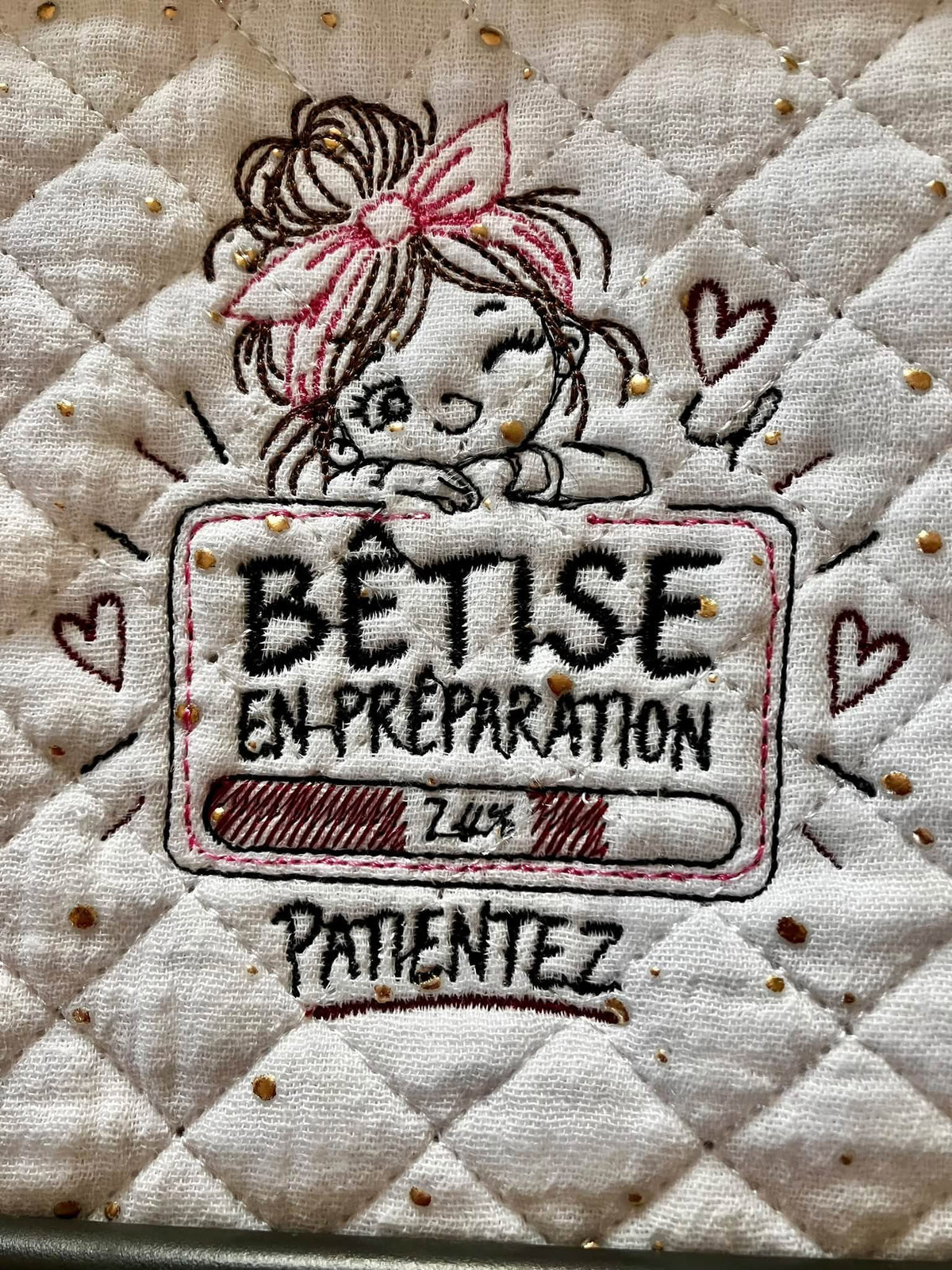 Bêtise en Préparation – petite fille malicieuse avec grand nœud rose et barre de chargement à 74 % – motif broderie machine 10x10