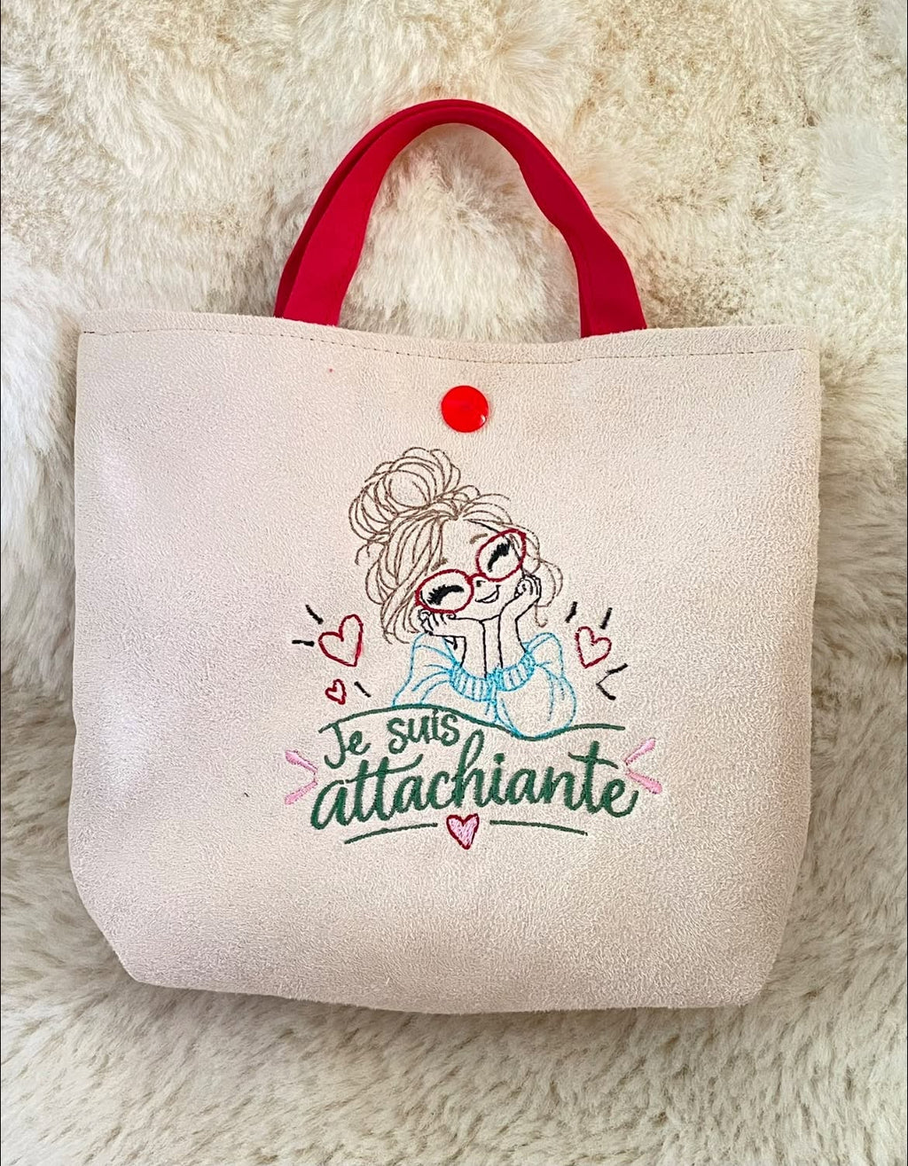 Je suis Attachiante – femme avec chignon, grandes lunettes rouges et petits cœurs – motif de broderie machine humour