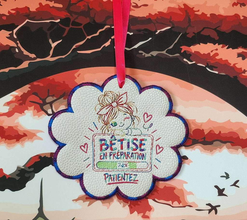 Bêtise en Préparation – petite fille malicieuse avec grand nœud rose et barre de chargement à 74 % – motif broderie machine 10x10
