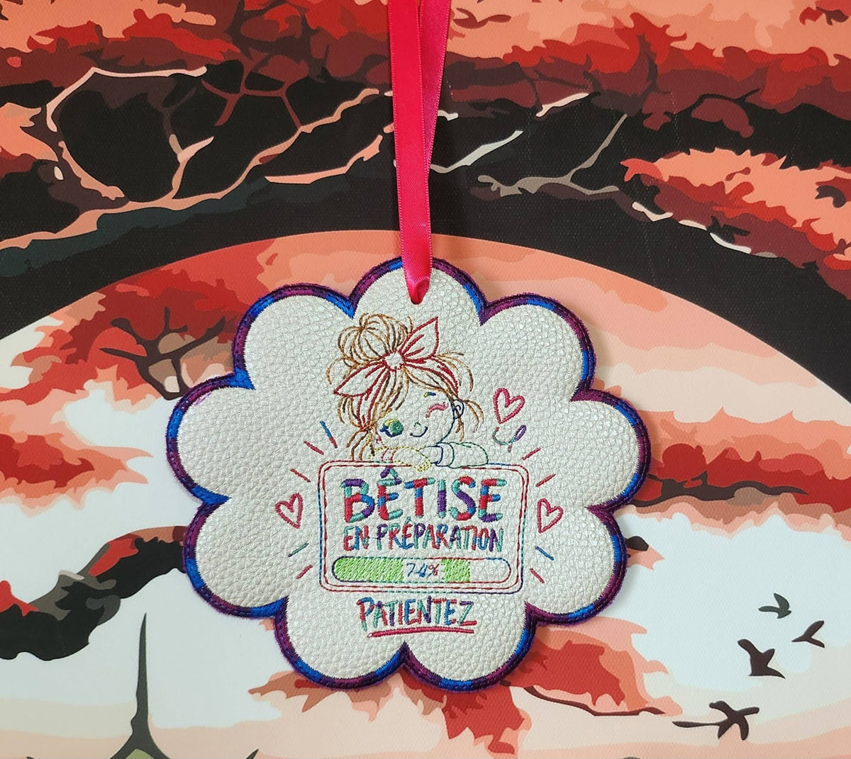 Bêtise en Préparation – petite fille malicieuse avec grand nœud rose et barre de chargement à 74 % – motif broderie machine 10x10
