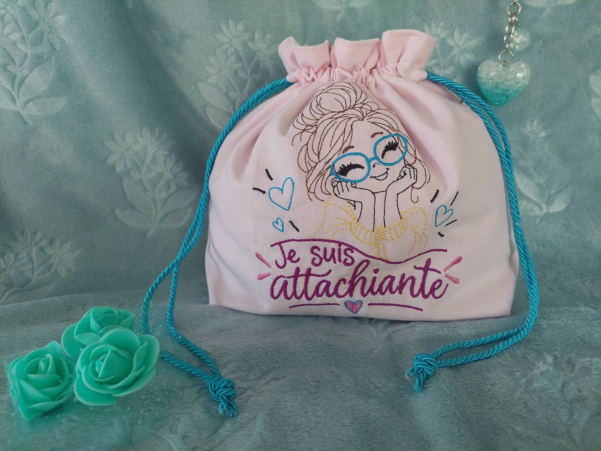 Je suis Attachiante – femme avec chignon, grandes lunettes rouges et petits cœurs – motif de broderie machine humour