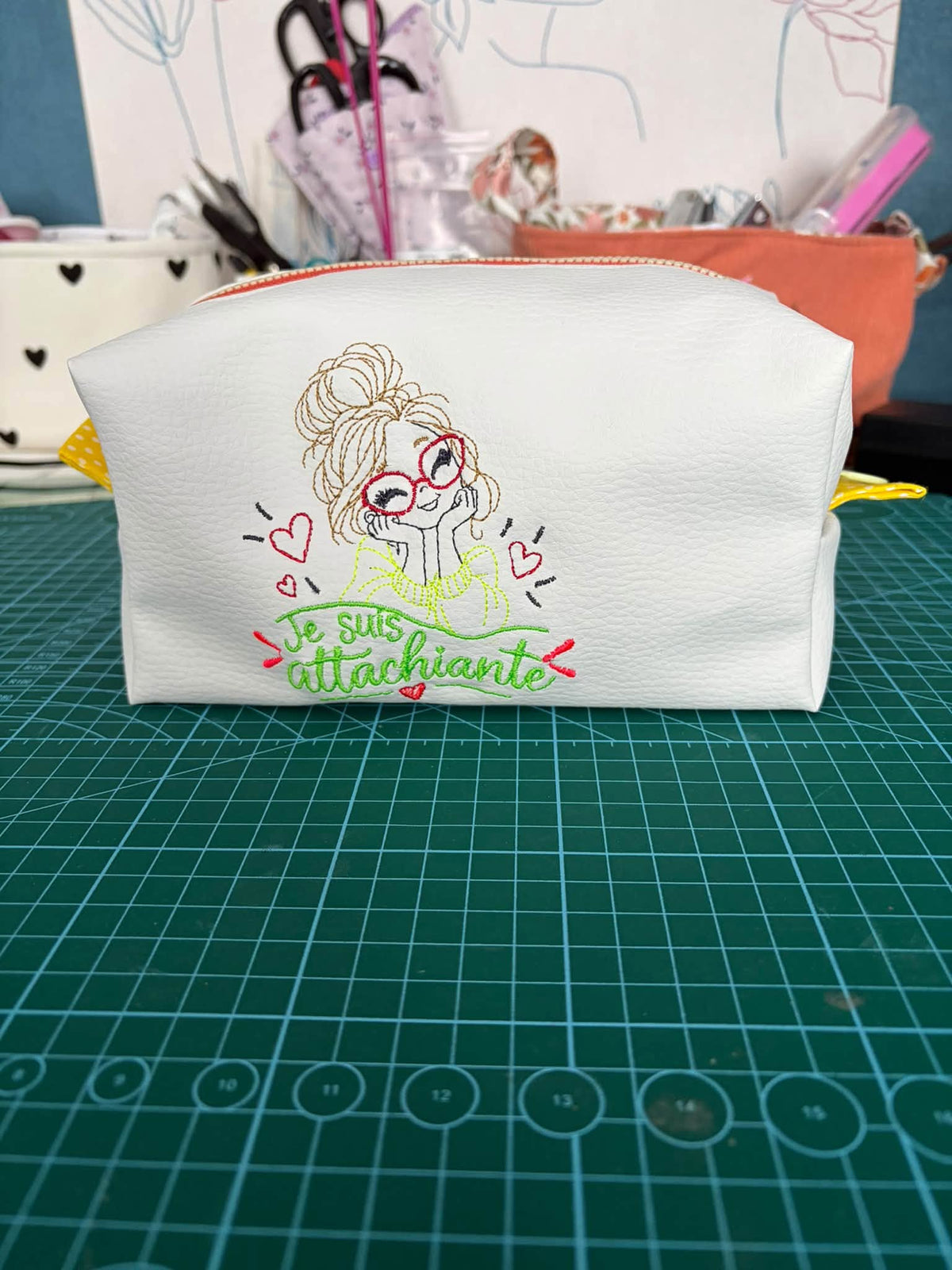 Je suis Attachiante – femme avec chignon, grandes lunettes rouges et petits cœurs – motif de broderie machine humour