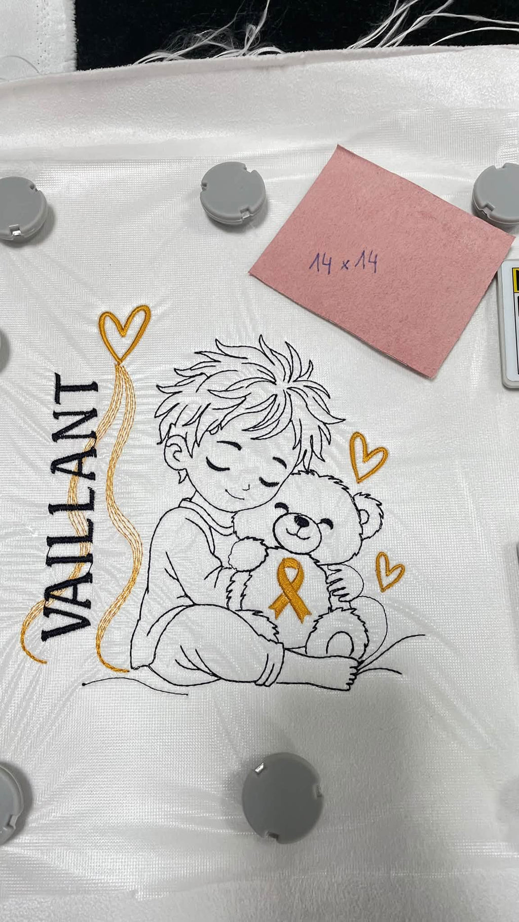 Le Petit Vaillant, petit garçon serrant un ourson avec ruban doré, cœurs et message VAILLANT – motif broderie Septembre en Or