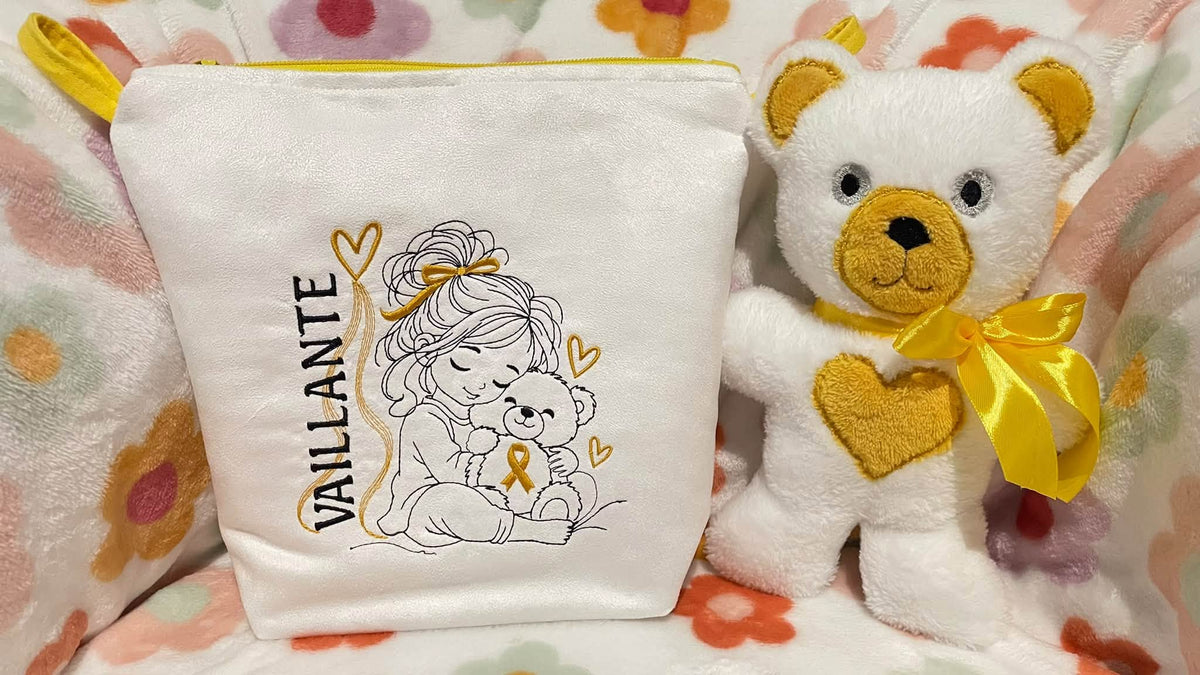 La Petite Vaillante, petite fille serrant un ourson avec ruban doré, cœurs et message VAILLANTE – motif broderie Septembre en Or