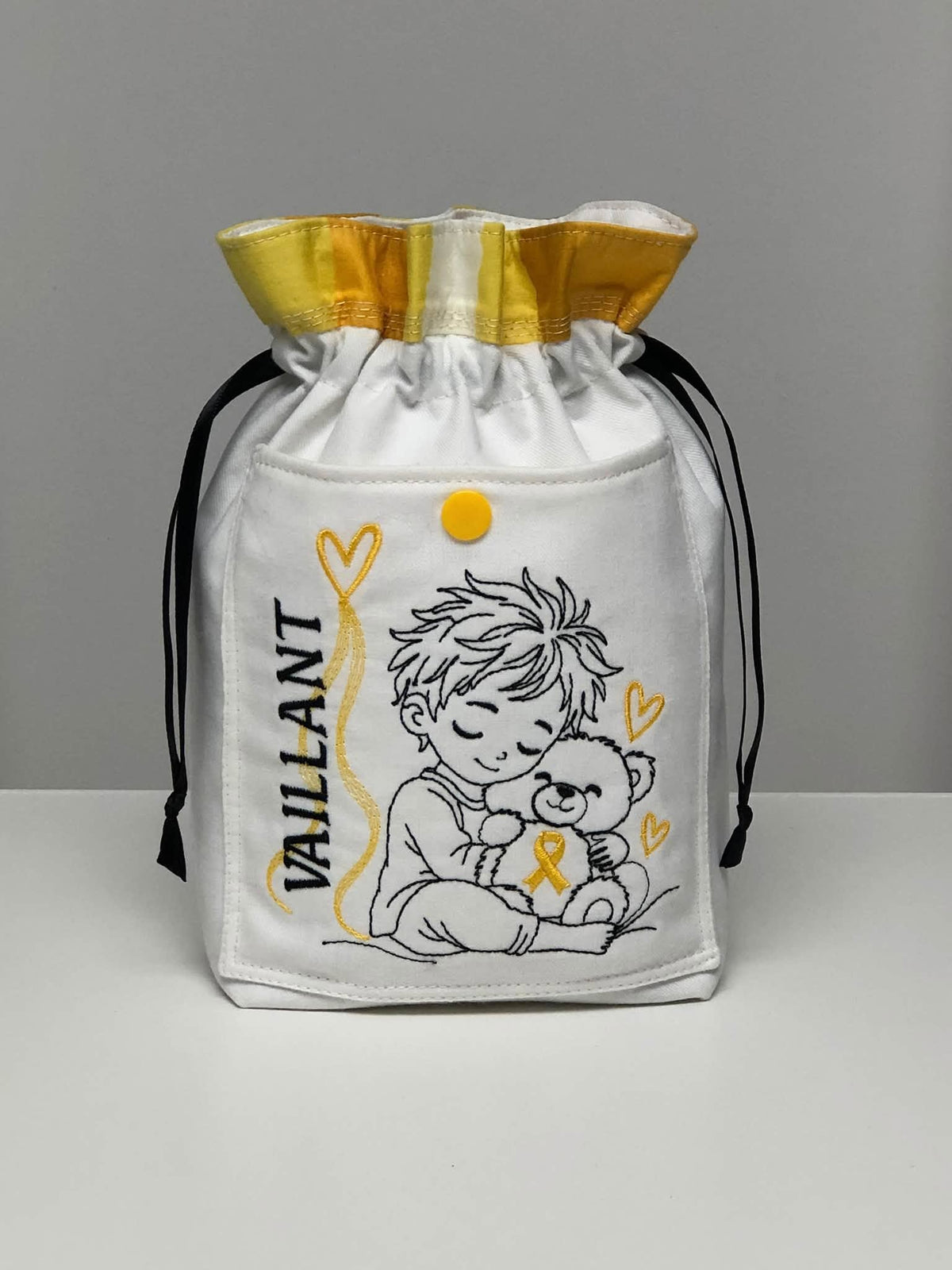 Le Petit Vaillant, petit garçon serrant un ourson avec ruban doré, cœurs et message VAILLANT – motif broderie Septembre en Or