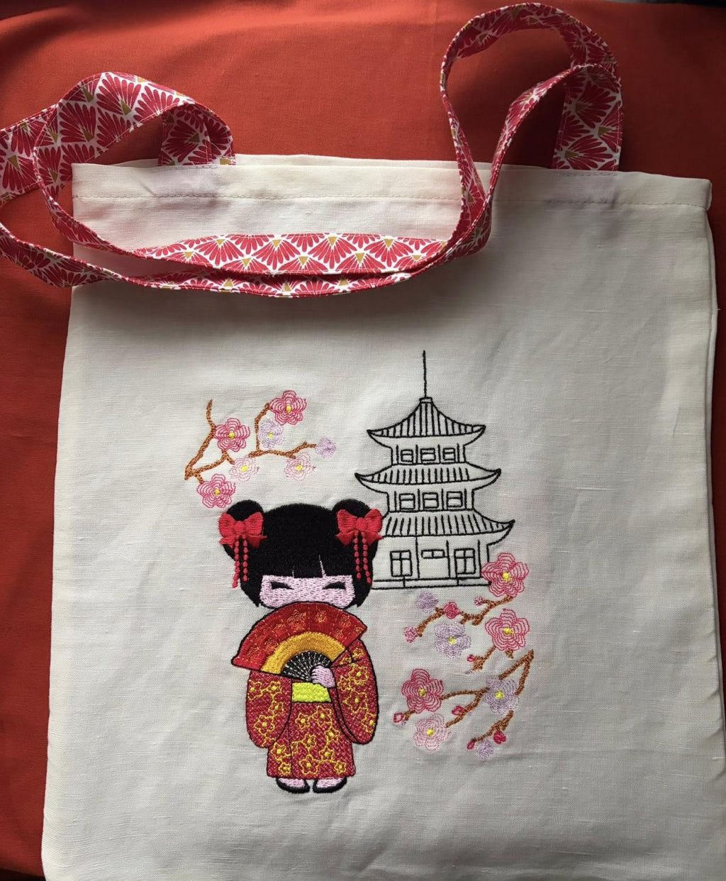 Kokeshi devant sa pagode - Fleurs de cerisier - Motif de broderie - Format disponible Pack 3 tailles, 10x10, 18x13, 20x20 ou 26x16